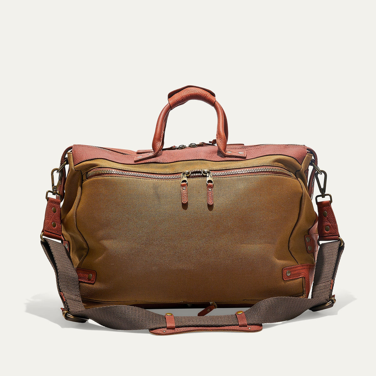 The WILL LEATHER GOODS Canvas and Leather Duffel in Tobacco/Cognac is open to show its roomy interior with a red and black plaid lining. Two matching plaid accessories from WILL LEATHER GOODS are displayed beside the bag.