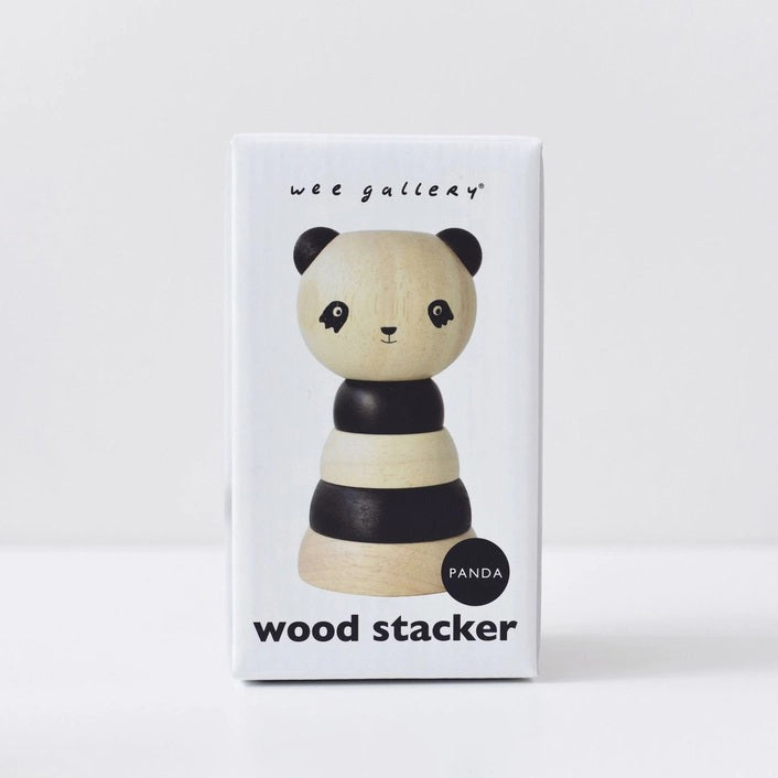 A white packaging box is labeled at the top with "WEE GALLERY" and at the bottom with "PANDA WOOD STACKER." The box features an image of a wooden stacker toy resembling a panda, consisting of alternating black and natural wood rings, designed to enhance fine motor skills through creative play.