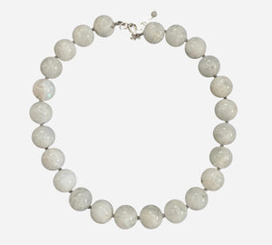 The ANN LIGHTFOOT - WHITE MOONSTONE RAS DU COU NECKLACE features smooth, large white moonstone beads and a sterling silver clasp, arranged in a circle on a white background.