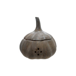 The STONEWARE GARLIC STORAGE by CREATIVE COOP is a light gray container with a speckled, reactive glaze, featuring a rounded base, tall tapered lid with stem, and side holes. Its rustic finish is perfect for stylishly storing garlic or onions.