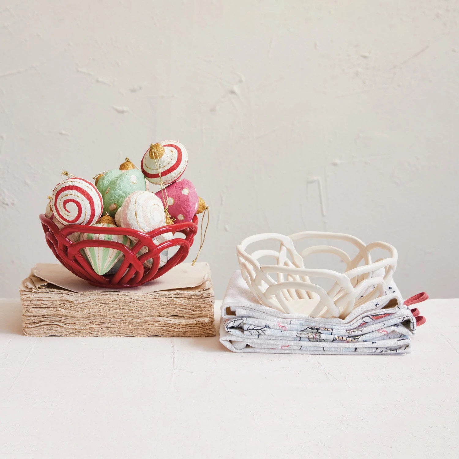 The HANDMADE STONEWARE BREAD BASKET by CREATIVE COOP is a white ceramic bowl showcasing an open, intertwined lattice design with multiple curved strands that create a visually intricate and delicate pattern. The empty bowl is displayed against a simple white background.