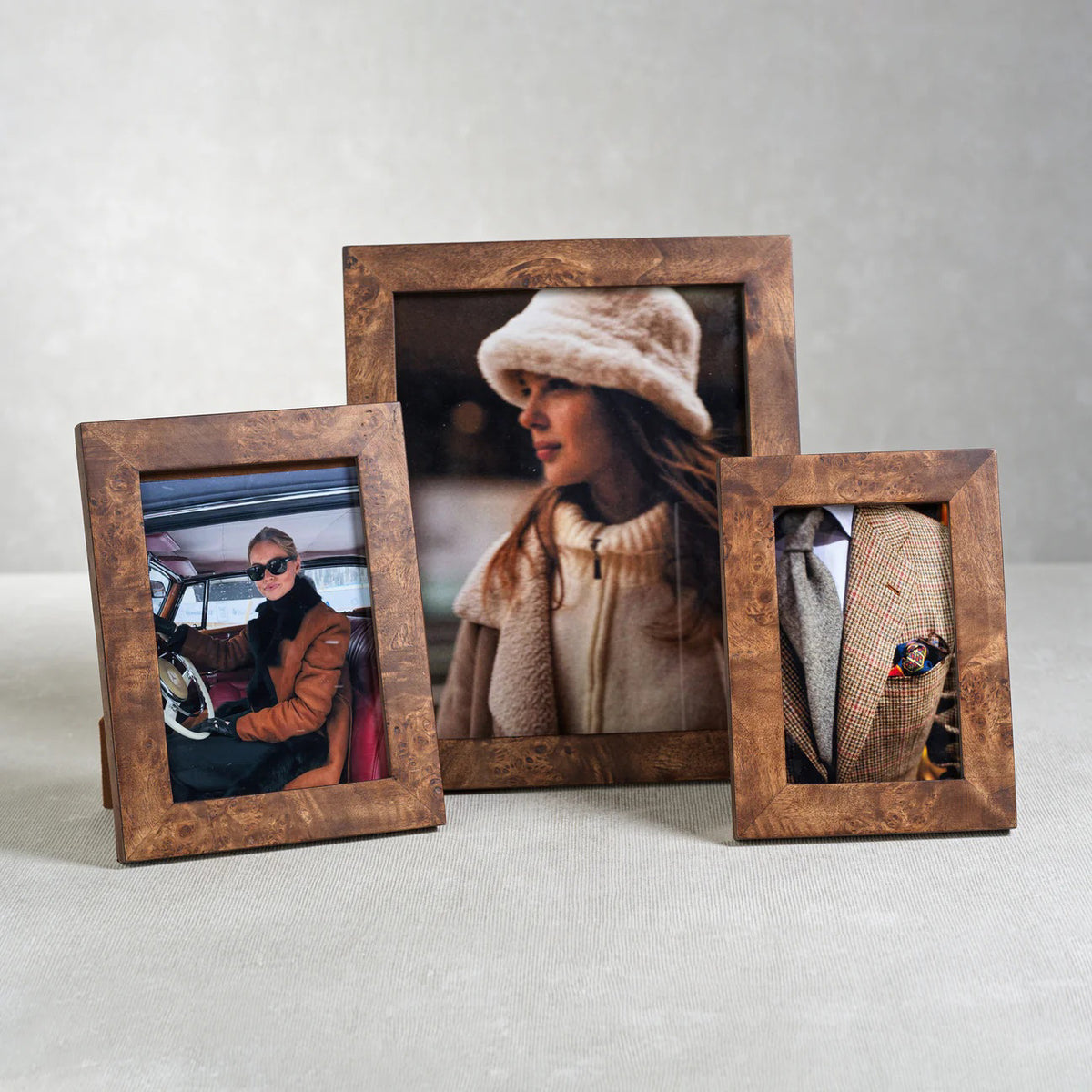 The ZODAX BURL WOOD PHOTO FRAME 5X7 displays a photo of a person in sunglasses and a brown coat seated in a car, standing elegantly against a white background.