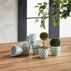 NAPA HOME AND GARDEN's Imperial Mini Flower Pot set includes six ceramic pots, each featuring unique green chinoiserie patterns with geometric and floral designs. Elegantly arranged in two rows on a white surface, these pots are available for in-store pickup.