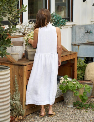 The FRANK & EILEEN - DAPHNE SLEEVELESS POPOVER DRESS is a sophisticated maxi dress in washed linen, featuring a collar and V-neck. This elegant dress by FRANK & EILEEN showcases a fitted bodice, a gathered flared skirt, and convenient side pockets. It is displayed against a white background.