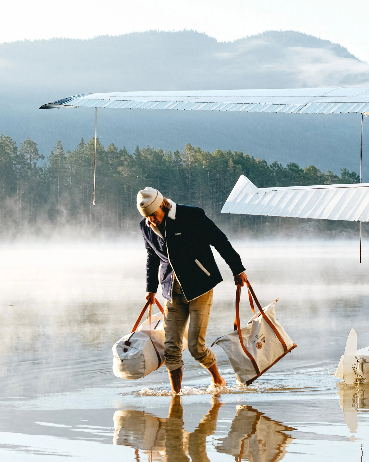 The AMUNDSEN SPORTS Harvester Overshirt in True Navy is a stretch cotton corduroy jacket with white sherpa trim, chest and side pockets, snap buttons, and a circular left-sleeve patch.
