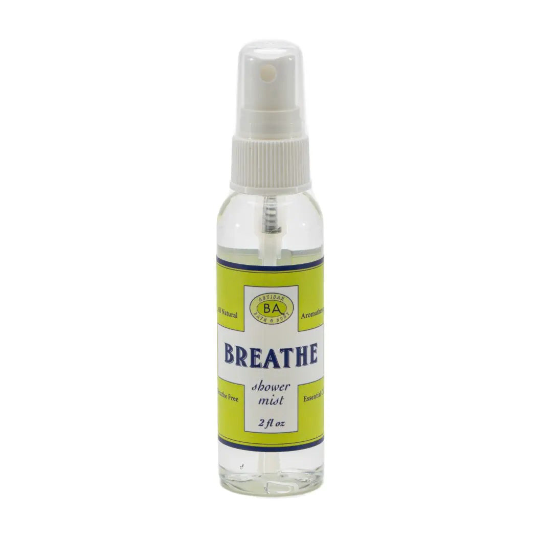 A small green plant in a face-shaped pot sits next to a large jar labeled &quot;BAUDELAIRE - BREATHE SHOWER MIST.&quot; Above, smaller bottles of eucalyptus essential oil and a wooden brush rest on a white shelf with a gray geometric background, creating an inviting space for your aromatherapy steam room.