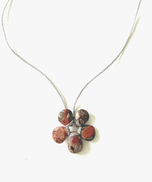 The ANN LIGHTFOOT - PETITE RED SPOTTED CHALCEDONY FLOWER NECKLACE showcases five marbled stones in warm browns and reds, resembling faceted spotted red chalcedony, elegantly held by silver wire and suspended from an adjustable braided nylon tie.