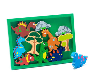 The WOOD DINOSAUR PLAY TRAY by BEST YEARS LTD is a vibrant children's wooden puzzle that features an array of fair-trade dinosaur toys and trees within a green rectangular frame. One blue dinosaur piece adorned with pink spots rests outside the frame. The puzzle includes sustainable wooden dinosaur toys in red, green, orange, and blue hues.