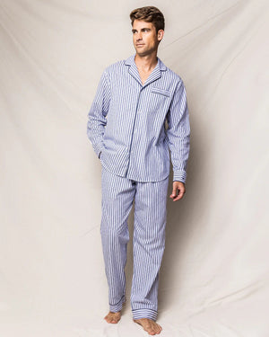 The FEARRINGTON LIFESTYLE COLLECTION - MENS TWILL NAVY FRENCH TICKING PAJAMAS by PETITE PLUME is neatly folded and displayed. This striped pajama set, made from the finest quality cotton, features white and navy blue vertical stripes in a traditional French ticking design with a small embroidered sheep on the chest pocket. It has a collar, buttons, and an attached hang tag with branding.