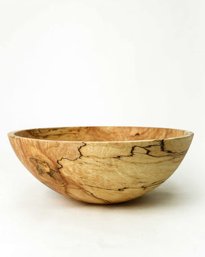 A Classic Round Spalted Maple Bowl 18" from Petermans Boards & Bowls Inc, expertly crafted from upcycled wood, holds a variety of fresh fruits: a bunch of green grapes, a brown pear, and a green pear, displayed against a plain white background.