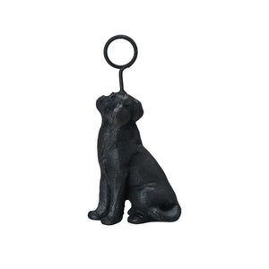 A black cast iron bottle opener from CREATIVE COOP, shaped like a sitting dog with its head raised. It features a circular loop at the top for opening bottles, merging charm and functionality.