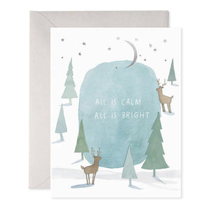 The "ALL IS CALM GREETING CARD" by E.FRANCES PAPER showcases a minimalist illustration of a deer by a small pond, encircled by trees. The design is printed on luxurious heavyweight paper and is accompanied by a gray envelope, featuring the brand’s name and a whale silhouette at the bottom.