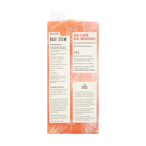 A red and black carton of KETTLE & FIRE - GRASS FED LOW SODIUM BEEF COOKING BROTH 32OZ. The front displays labels such as "100% Grass-Fed," "No Preservatives," "Low Sodium," and "Beef Broth." With a 32 oz (907g) capacity, icons indicate it is a slow-simmered, high-quality cooking broth perfect for enhancing recipes.