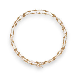 The GAS BIJOUX - ROSARIO NECKLACE by GAS BIJOUX is a double gold plated necklace featuring alternating twisted gold links and small mother-of-pearl beads. It boasts an elegant circular clasp, with evenly spaced strands that create a balanced, luxurious appearance. The necklace is arranged in a circular shape for display.