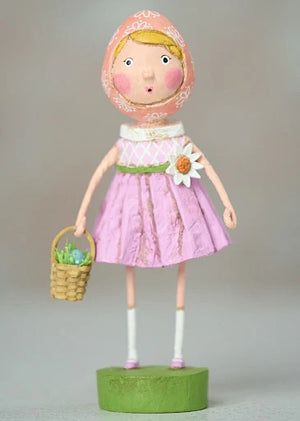 The ESC AND COMPANY - SHELLY FIGURINE by ESC AND COMPANY, INC is a whimsical poly resin piece featuring a girl in a pink dress and headscarf. At 6.25" tall, she holds a basket with green contents on a green base adorned with floral details and wears a surprised expression.