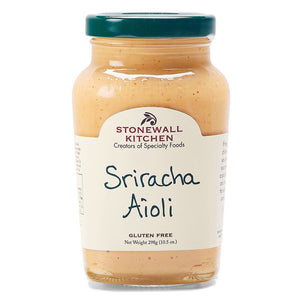 A jar of STONEWALL KITCHEN-SRIRACHA AIOLI is displayed. The label is white with the brand name and product type written in red and black text. This 10.5-ounce (298-gram) jar of Sriracha Aioli, marked gluten-free, promises a flavorful kick as a spicy dipping sauce for any dish.