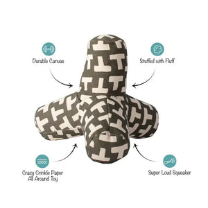 The FRINGE STUDIO - ODETTE OLIVE CANVAS SQUEAKER DOG TOY by PET SHOP BY FRINGE STUDIO is a plush toy designed in the shape of a three-pronged jack. Made from durable cotton canvas, it is covered with an olive fabric featuring a pattern of white "T" letters scattered across the surface. Utilizing non-toxic inks, this soft-textured toy offers both comfort and fun for your pet.