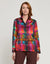 A person with shoulder-length auburn hair is shown from the back, wearing the HINSON WU - Margot Long Sleeve Satin Shirt in Festive Plaid. The multicolored plaid shirt features a collar and includes shades of red, green, yellow, and pink. It is paired with brown pants.