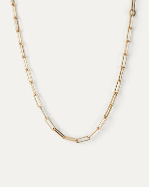 The JENNYBIRD ANDI SLIM NECKLACE is a high-polish gold paperclip necklace featuring elongated, rectangular links, showcased against a plain white background. With an elegant design of alternating small and larger links, it offers adjustable length for a refined and modern appearance.