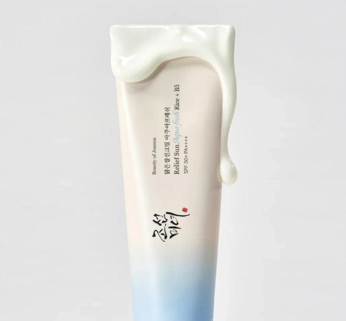 The BEAUTY OF JOSEON RELIEF SUN AQUA FRESH SPF50 by GLOWISS features Korean text with a gradient design transitioning from white to light blue, capped in blue. Experience its lightweight texture for hydrating, non-greasy protection.
