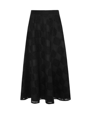 The SFIZIO - PATCHWORK CROCHET SUEDE CIRCLE SKIRT by SFIZIO is a black A-line midi skirt that features a checkered pattern with alternating solid and crochet knit squares, offering a modern look. The hemline falls slightly below the knee, adding an elegant touch to this patchwork design. Made in Italy.