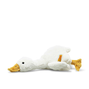 The STEIFF GILDA GOOSE PLUSH TOY by STEIFF is a whimsical plush toy resembling a white goose lying on its belly, with a yellow beak and feet visible. The toy appears softly stuffed and cuddly, featuring a small tag attached to its side—perfect as your child's new barnyard buddy.