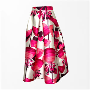 Introducing the MIDI STRUCTURED SKIRT by ALYKI LABORATORIO, a high-waisted A-line skirt that showcases a striking abstract floral pattern in vibrant shades of pink and red on a cream backdrop. Crafted in Italy, this voluminous piece features soft, elegant pleats for a refined yet bold look.