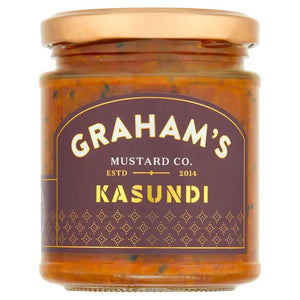 A jar of Graham's Irish Kasundi Chutney with a black and gold label. The label displays the brand name "Graham's," the product name "Irish Kasundi Chutney." This zesty condiment is perfect for a cheeseboard and brings a touch of gourmet elegance to any spread. The jar is sealed with a black lid.