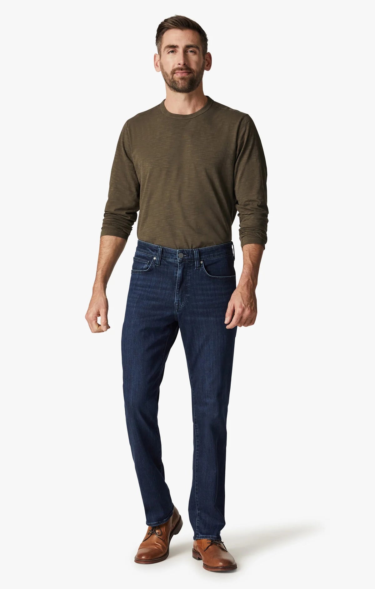 A man in a green long-sleeve shirt, brown shoes, and 34 HERITAGE Charisma Relaxed Straight Leg Jean in Dark Midnight Brushed Urban wash stands with his back to the camera against a plain white background.