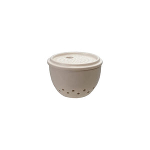 The CREATIVE COOP STONEWARE GARLIC AND GINGER GRATER CONTAINER is a beige ceramic bowl with a lid, designed for garlic storage, featuring multiple small holes around the bottom.