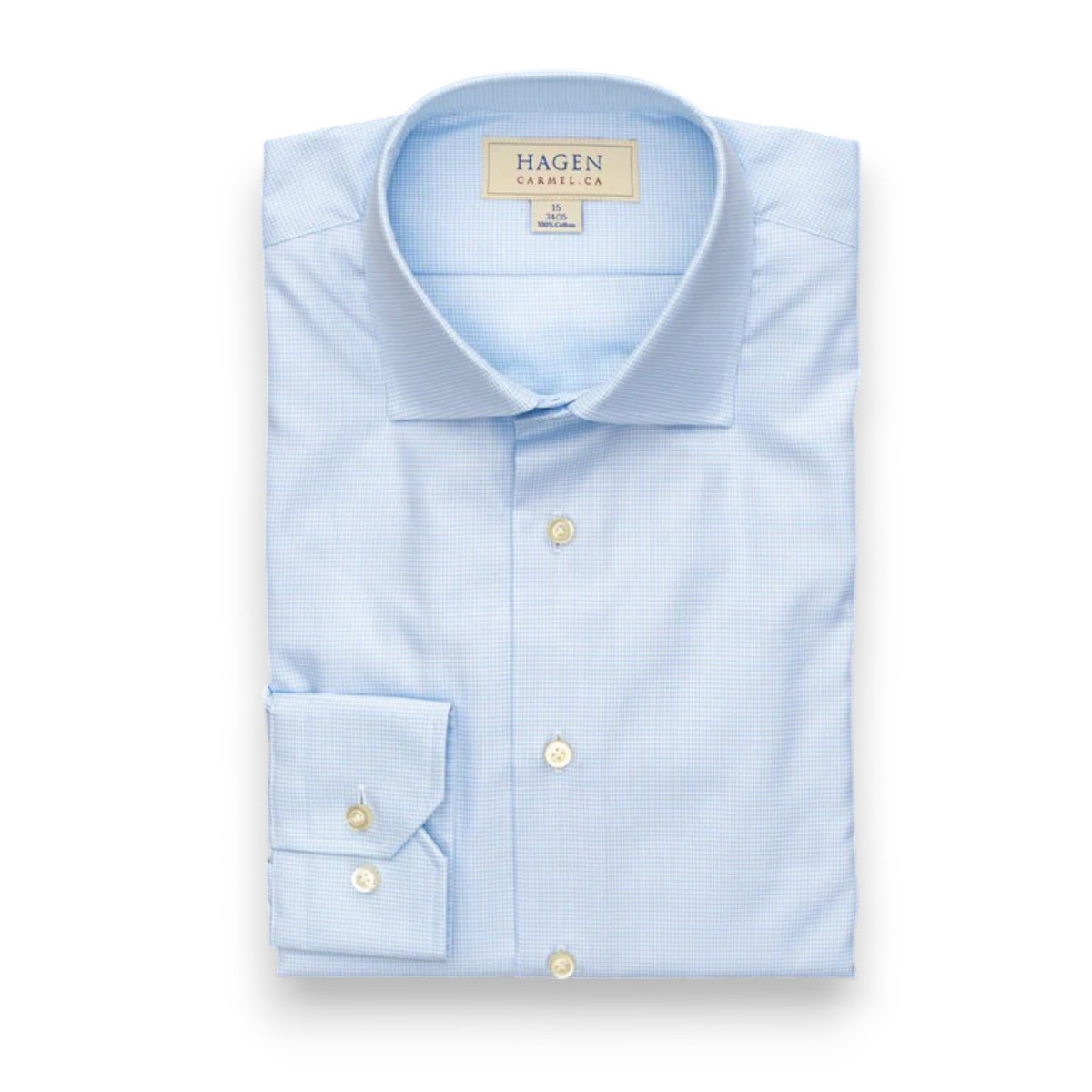 The HAGEN - COTTON DRESS SHIRT IN SKY MINI HOUNDSTOOTH features a modern spread collar, white buttons, and premium cotton fabric. The neatly folded shirt displays the Hagen label and comes in a light blue mini houndstooth pattern.