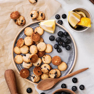 A blue and gray checkered box of Memaw’s Country Kitchen Blueberry Shortbread from 1 in 6 Snacks. The text highlights "bitesized with big blueberry taste." An image of the cookies is visible on the side, along with "Where treats & memories are made." These American homemade cookies have a net weight of 4 oz (113g).