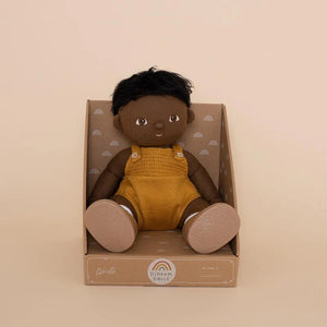 A DINKUM DOLL from OLLI ELLA USA features soft brown hair and comes dressed in a white knit romper paired with brown shoes. This charming doll has an embroidered face with brown eyes, a small nose, and a gentle smile. Its posable body makes it perfect for imaginative playtime, and it is posed standing upright.