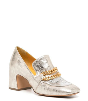 The LEATHER MID HEEL LOAFER WITH CHAIN by MADISON MAISON is a luxurious mid heel loafer crafted in metallic silver leather, showcasing a square toe and an elegant gold chain detail across the top. Featuring a medium height, the handmade Italian craftsmanship is evident in its subtle textured finish.