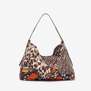 The INOUI EDITIONS MAXI CAMPUS BAG PAPILLON by INOUI is a hobo-style cotton bag with a curved handle, showcasing a vibrant butterfly wing pattern in orange, black, blue, and cream on a plain white background.