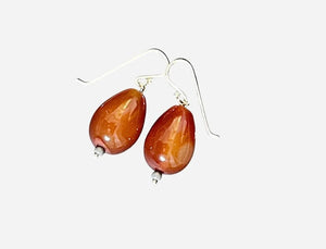 The ANN LIGHTFOOT CARNELIEN TEARDROP EARRINGS feature glossy brown beads with silver accents on sterling silver hooks, shown against a plain white background.