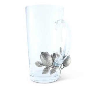 The VAGABOND HOUSE Pitcher features a clear glass design with a handle adorned in decorative pewter lemons and leaves, adding an elegant touch that seamlessly blends Italian glass artistry with simplicity.