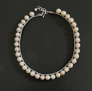 Introducing the ANN LIGHTFOOT - FRESHWATER PINK PEARL COLLIER NECKLACE, featuring a single strand of beautifully irregular freshwater pink pearls, each artfully separated by decorative knots and finished with a sterling silver clasp.