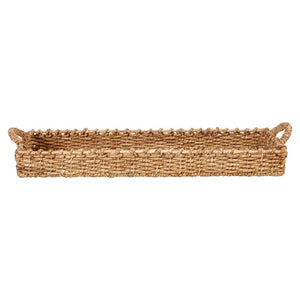 The HANDWOVEN SEAGRASS TRAY WITH HANDLES by CREATIVE COOP is a rectangular basket with short sides and small end handles, made from hand-woven seagrass. It features a natural fiber texture and light brown color, ideal for serving or as an accent piece.