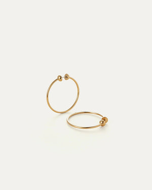 The JENNY BIRD - ICON HOOP EARRINGS SMALL, crafted from high-polish gold stainless steel by JENNYBIRD, offer a minimalist design. Their lightweight, hollow construction includes waterproofing and flexibility for easy opening, while a 360-degree closure prevents hair from catching.