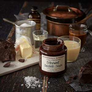 A jar of STONEWALL KITCHEN- BITTERSWEET CHOC SAUCE, featuring a green lid and a white label with green and brown text, labeled gluten-free with a net weight of 354 grams (12.5 oz). A classic from STONEWALL KITCHEN, renowned for its rich chocolate flavor, making it ideal as a hot fudge sauce.