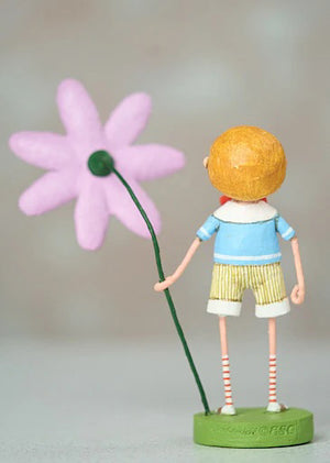 The 7" Billy Bloom Figurine by ESC and Company, Inc. showcases a rosy-cheeked child in a blue top and striped shorts, holding a big pink flower. Crafted from durable poly resin, it stands on a green base set against a neutral background.