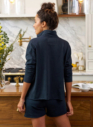 The FRANK & EILEEN Patrick Popover Henley in Jersey features a dark navy blue color with long sleeves, a relaxed fit, and an open collar. Its soft, slightly textured fabric gives it a casual and comfortable look. The shirt is laid out flat against a light, textured background.