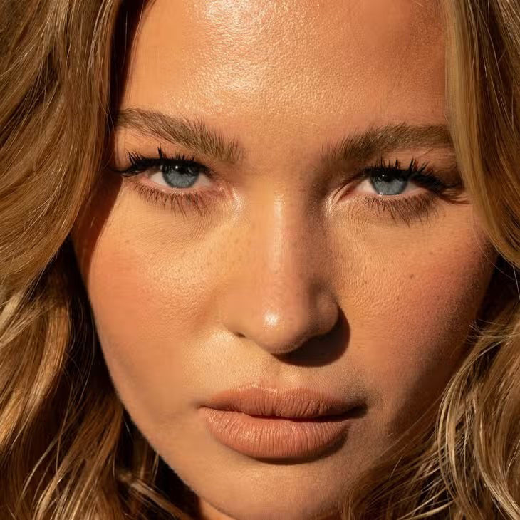 A cylindrical makeup product labeled 