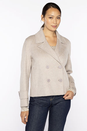 Someone wearing the KINROSS Cashmere Short Trench Coat in light gray and dark jeans stands against a plain white background, looking at the camera with a slight smile.