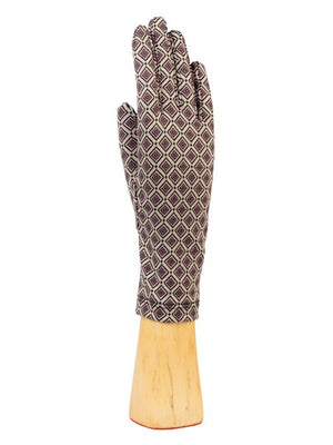 The STRETCH KNIT GEOMETRIC CHECK GLOVES by SANTACANA MADRID WORLD GLOVE COMPANY showcase a stylish geometric design of small red and white diamonds on a black background. Displayed vertically, the gloves rest elegantly on a wooden stand against a plain white backdrop, enhanced by soft wool lining that combines comfort with visual appeal.