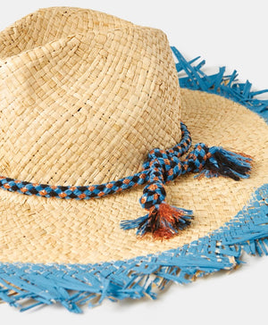 Introducing the TALLULAH RAFIA SUMMER HAT by MOMONI: This exquisite natural raffia hat boasts a wide, fringed brim with a distinctive frayed blue edge. Adorned with an elegant blue and white chenille and lurex hatband tied around the base of the crown and accented by a delicate tassel, this hat is showcased against a plain white background.