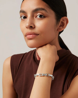 The JENNY BIRD - LOIRE BRACELET by JENNYBIRD is a silver chain bracelet with faceted cable links and a foldover clasp, shown on a plain white background. The clasp features small engraved initials.