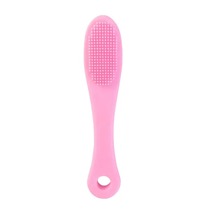 A pink LIP SCRUBBER by DAILY CONCEPTS stands next to its white and pink packaging. The packaging includes instructions for use and details about the product&#39;s texture and gentleness. The silicone lip brush features a textured surface perfect for exfoliating lips.