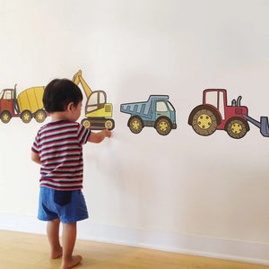 Four colorful construction vehicles arranged in a grid on a white background. The playful, cartoon-style vehicles include a red tractor, an orange cement mixer, a yellow excavator, and a blue dump truck. These vibrant SIMPLE SHAPES - CONSTRUCTION VEHICLE REMOVEABLE WALL DECALS by SIMPLE SHAPES are perfect for decorating any child's room.